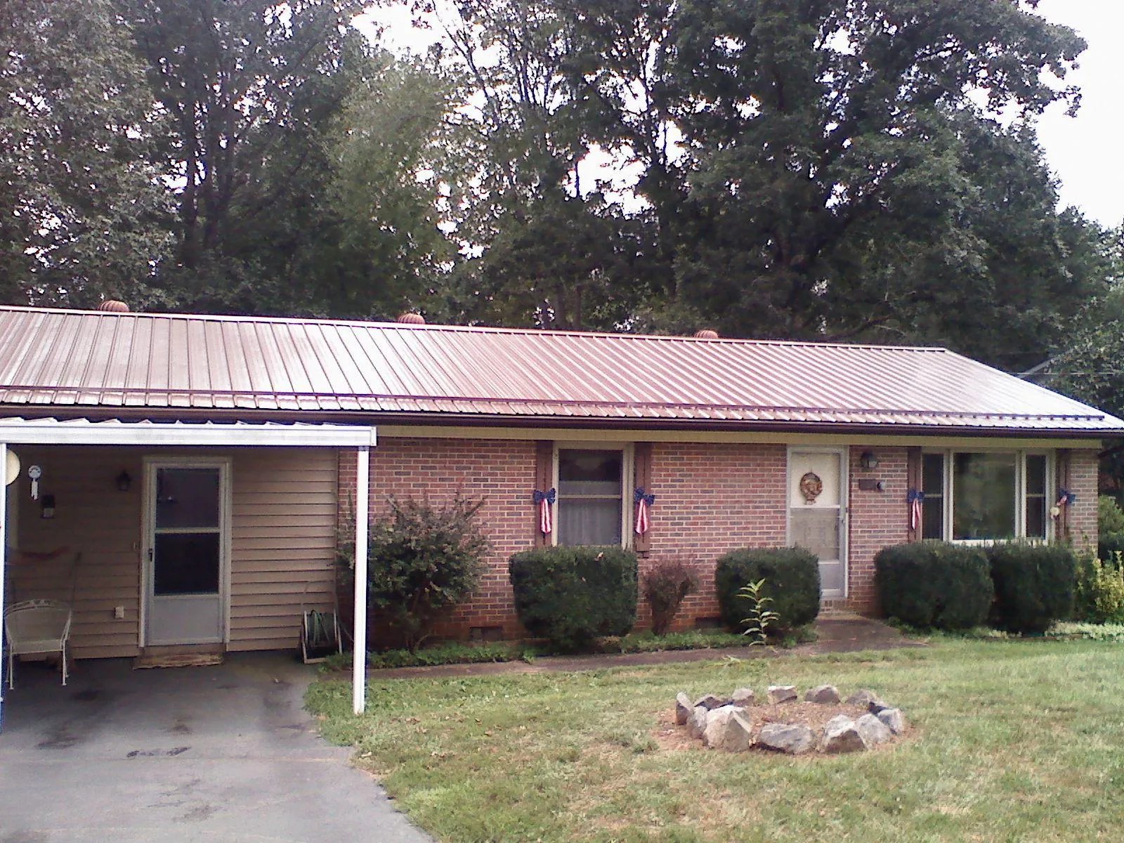 Bronze metal roof and carport on a brick ranch home — Roof Repair work by our crew in Harrisville